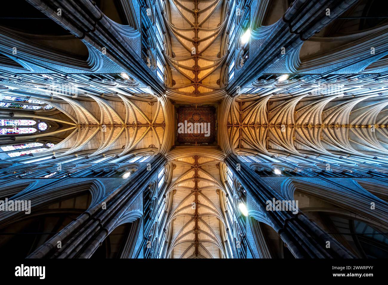 Gewölbte Decke einer gotischen Kathedrale mit komplizierten Rippenmustern und Buntglasfenstern. Stockfoto