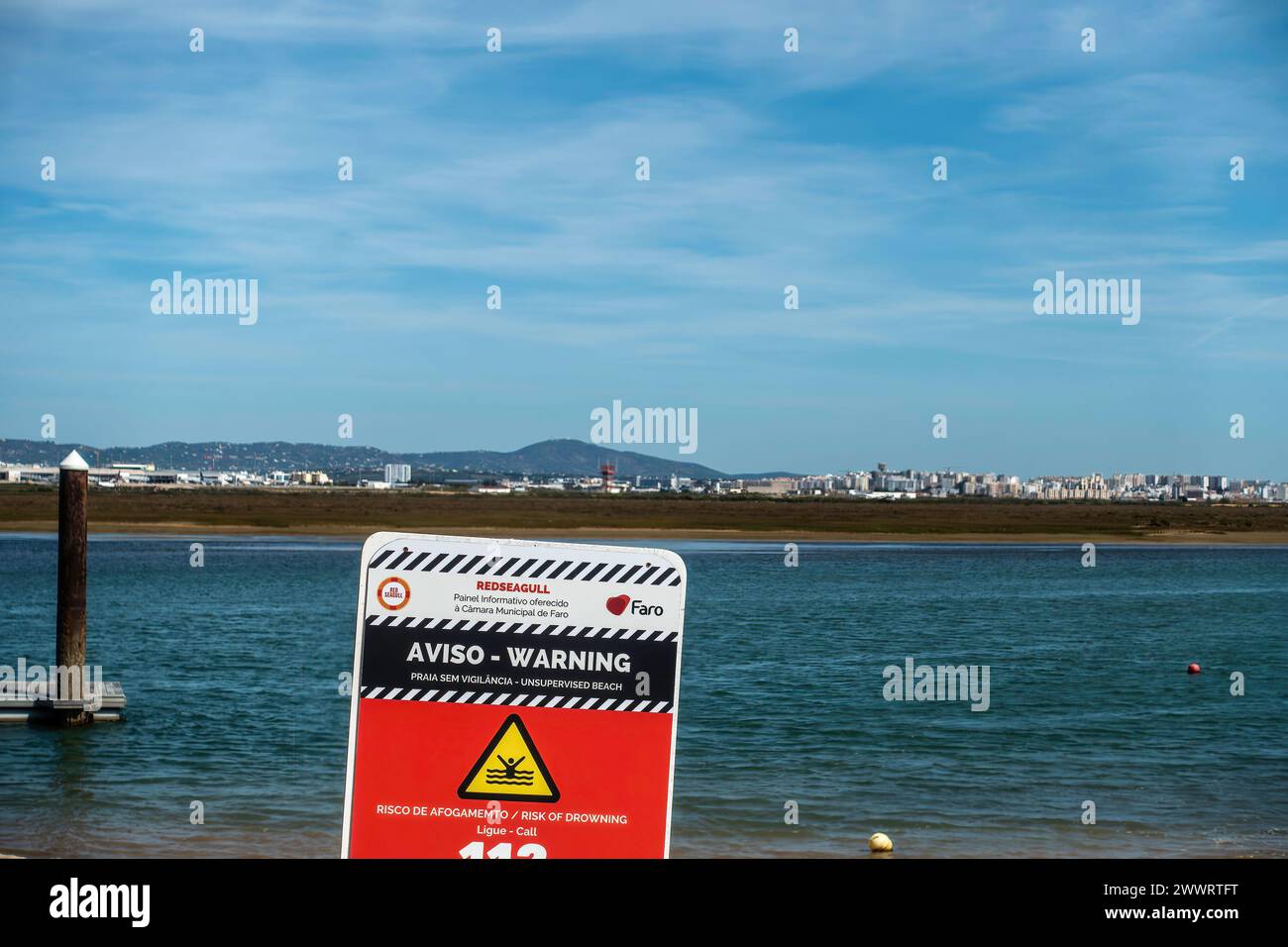 Ein Warnschild in Praia de Faro, Faro, Portugal, vor einem unbeaufsichtigten Strand und der Gefahr des Ertrinkens. Stockfoto