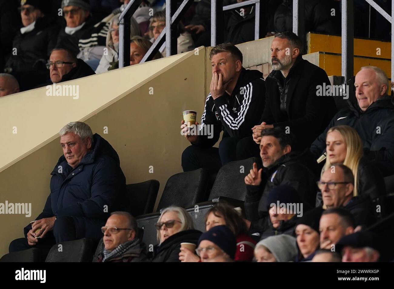 Salford City-Cheftrainer Karl Robinson (Mitte) sitzt neben Salford City-Fußballdirektor Ryan Giggs (rechts) und dem ehemaligen Newcastle United-Trainer Steve Bruce (links unten) während des Spiels der Sky Bet League Two in der Meadow Lane in Nottingham. Bilddatum: Samstag, 23. März 2024. Stockfoto