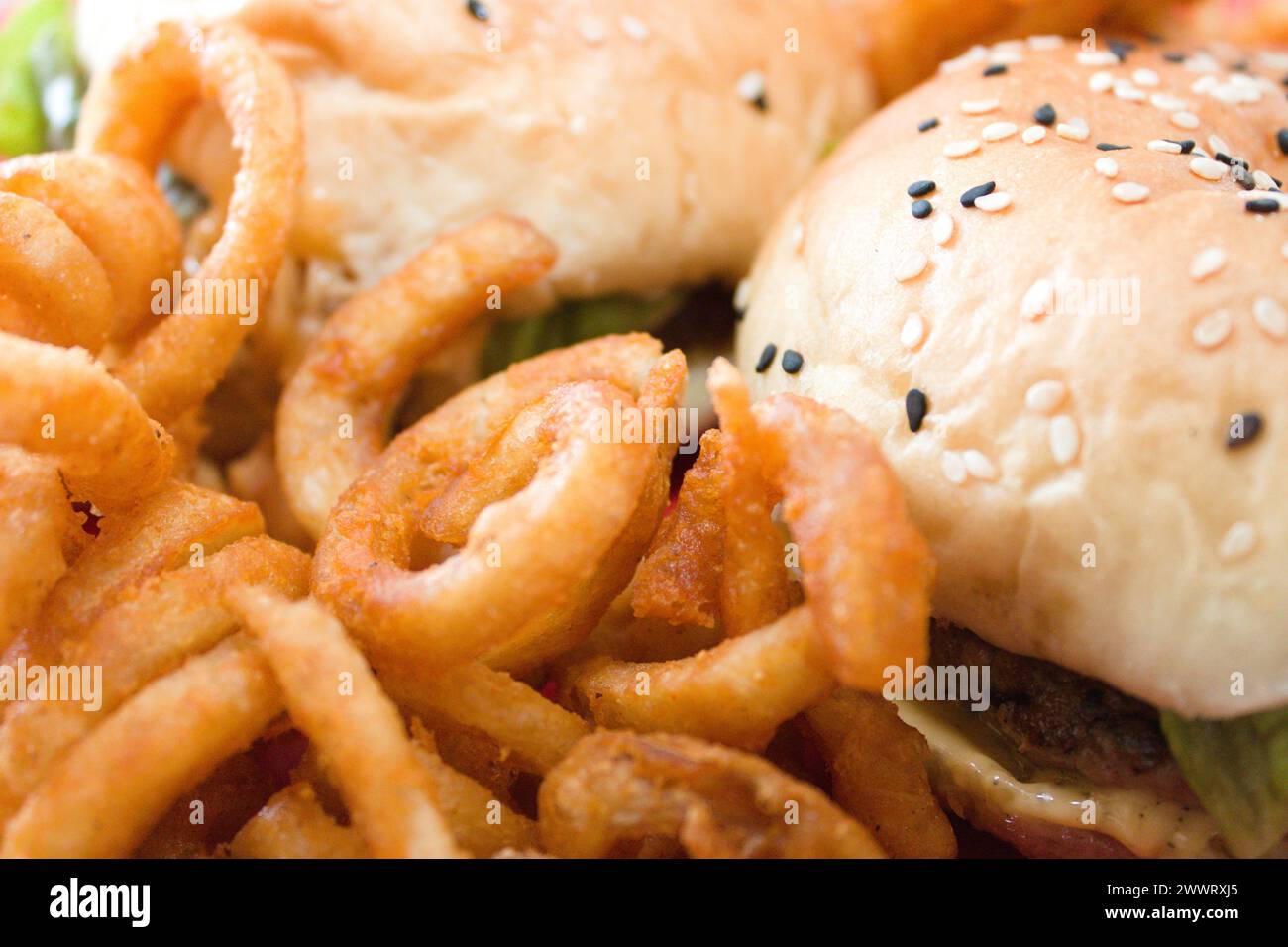 Eine Nahaufnahme eines Hamburger, Zwiebelringe und Salat Stockfoto