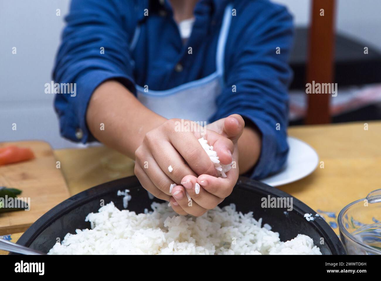 Junge, der hausgemachtes Sushi zubereitet. Kinderfreundliche Aktivitäten In Der Küche Stockfoto