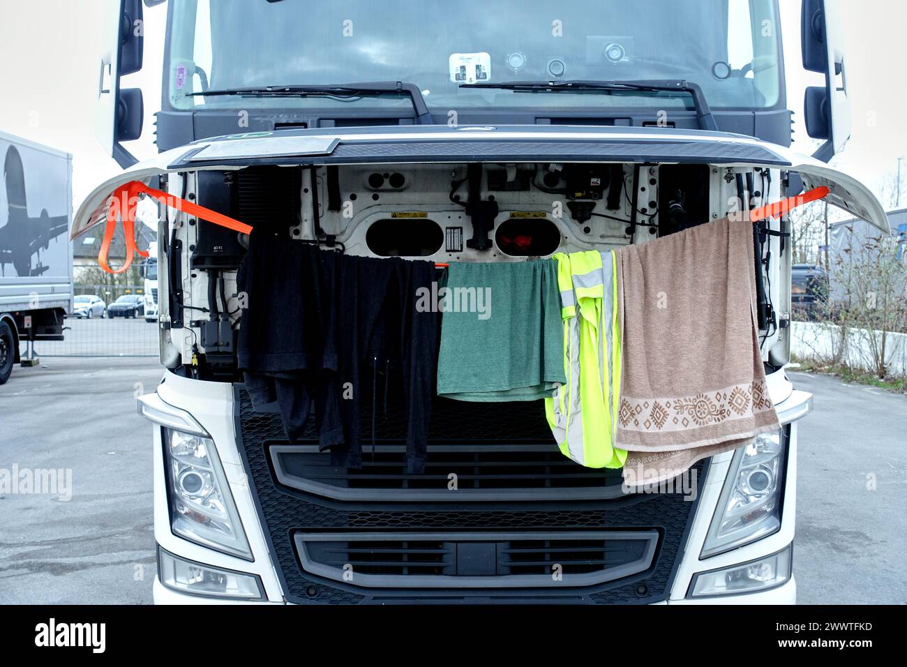 Trucker trocknet seine Wäsche am Motor mit geöffneter Motorhaube, Deutschland Stockfoto