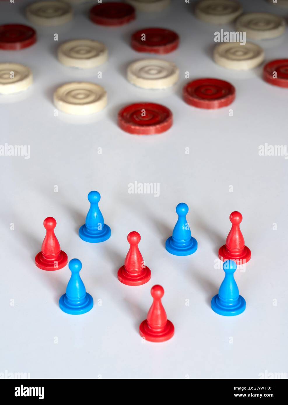 Rot-blau-Teams stehen zusammen. Das alte Spiel spielt im Hintergrund und das neue Spiel beginnt. Spielsteine, Markierungen, Spielfiguren sind bereit für den Kampf. Stockfoto