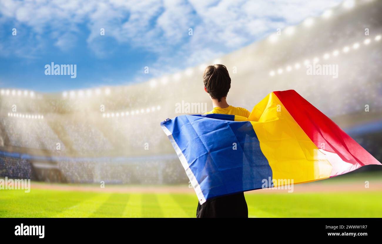 Rumänischer Fußballfan im Stadion. Rumänische Fans auf dem Fußballfeld beobachten das Spiel der Mannschaft. Gruppe von Fans mit Flagge und Nationaltrikot Stockfoto