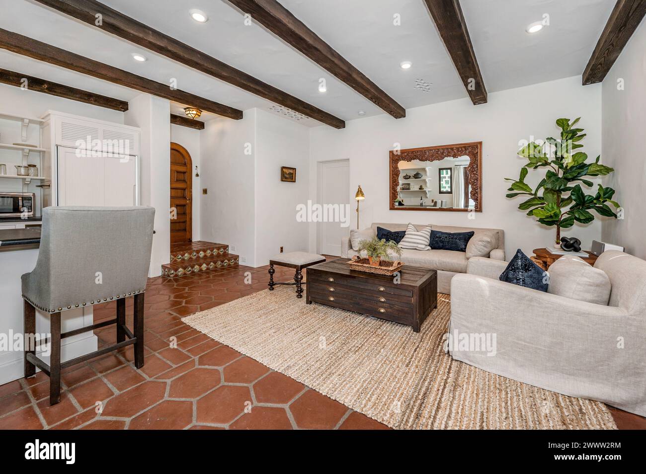 Wohnzimmer mit weißer Couch und Stühlen neben der Küche Stockfoto