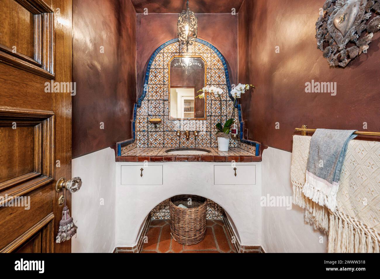 Geräumiges Bad mit gefliesten Wänden und Spiegel über dem Waschbecken Stockfoto