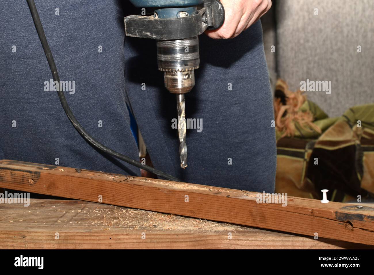 Holzarbeiter, der eine Bohrmaschine benutzt, um ein Loch an Holzteilen im Schraubstock zu machen. Hochwertige Fotos Stockfoto