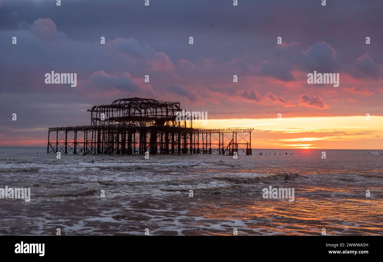 Sonnenuntergang hinter den Ruinen des West Pier an der Brighton Küste östlich von Sussex Südosten Englands Großbritannien Stockfoto
