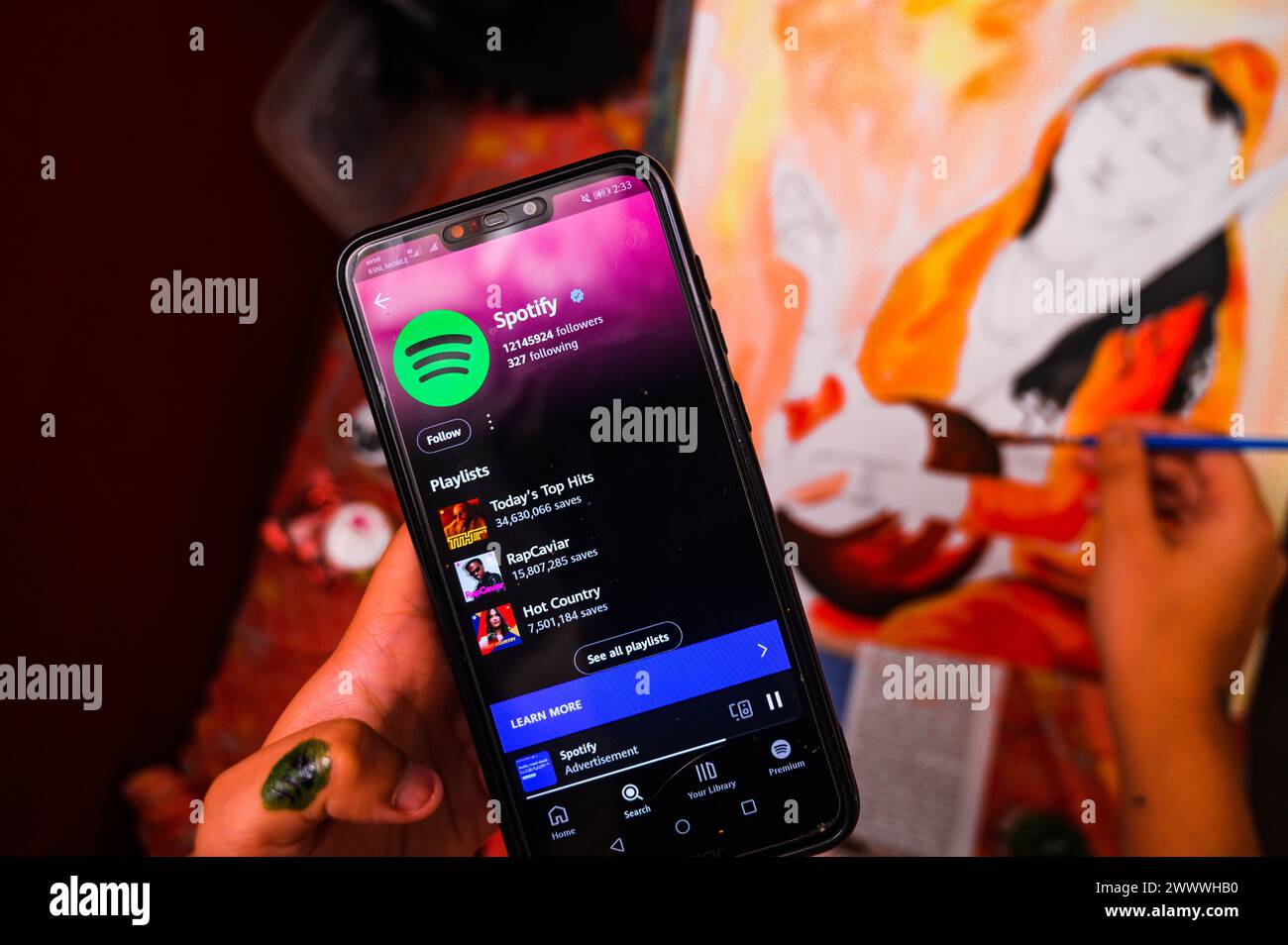 Ein Mädchen zeichnet ein Bild von „Mirabai“ (ein mystischer Dichter aus dem 16. Jahrhundert und Anhänger Krishnas), während er Musik in der Spotify App hört. Laut dem kürzlich veröffentlichten dat ist der weltweite Konsum von Musik aus Indien in den letzten fünf Jahren auf der Spotify-Plattform um mehr als 2.000 % gestiegen. Aktuelle Daten des Marktmonitors Luminate lassen vermuten, dass Indien nach Volumen schon bald der größte Musikstreamer der Welt sein könnte. 2023 streamen Musikzuhörer in Indien 1,037 Billionen Musik- und Musikvideos, hinter den USA nur 1,454 Billionen Stücke. Westbengalen; Indien. Stockfoto