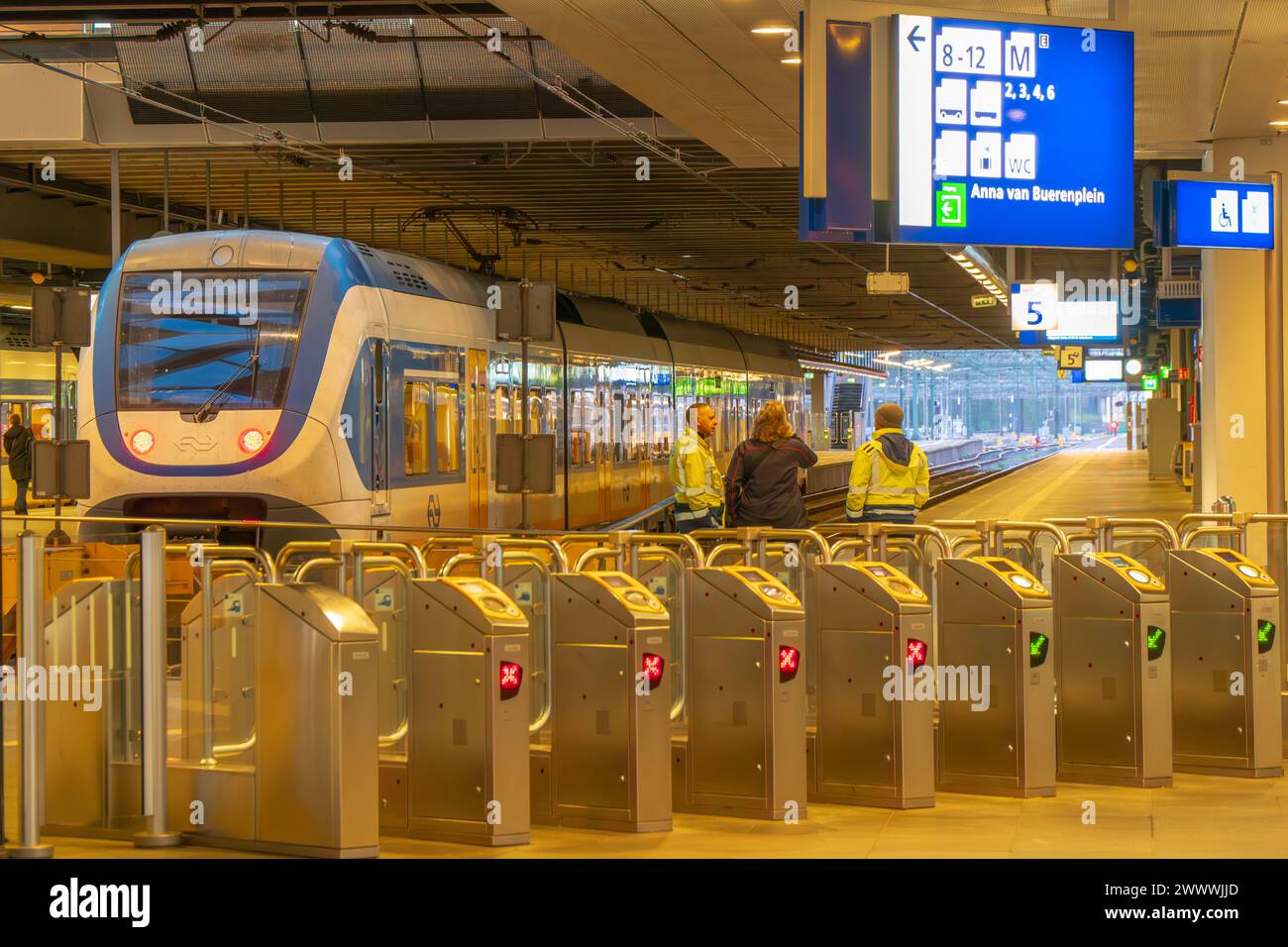 Sprinter Zug von NS Nederlandse Spoorwegen niederländischer Eisenbahnbetreiber am Haager Hauptbahnhof. Am frühen Morgen. Sicherheitstore, trainiere persönlich. Stockfoto