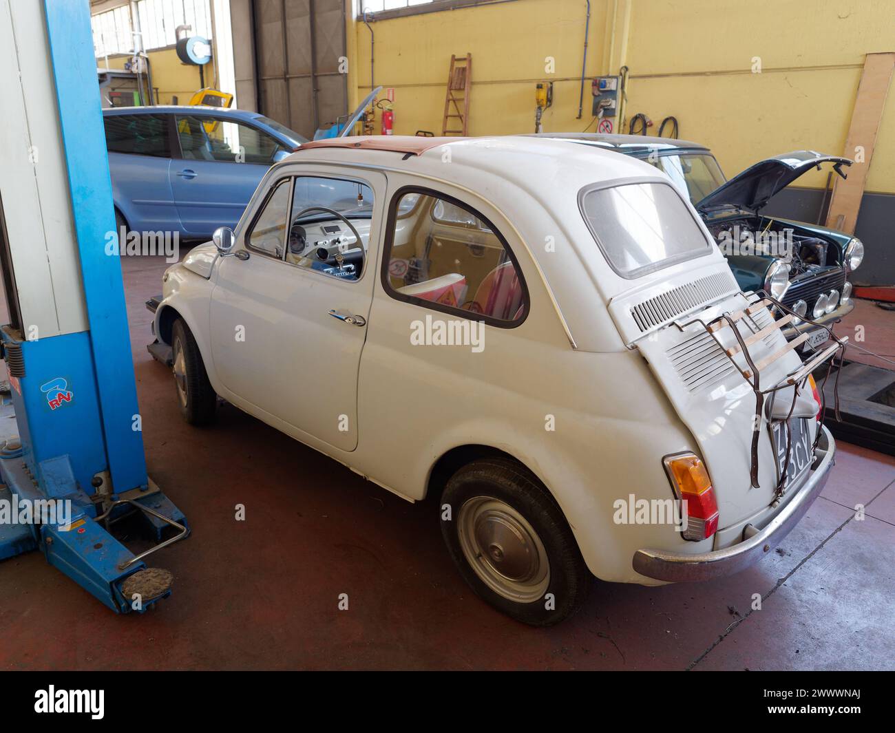 White Classic Fiat 500 in einer Mechanikerwerkstatt, die Arbeiten in Montefiascone, Region Latium, Italien erfordert. März 2024 Stockfoto