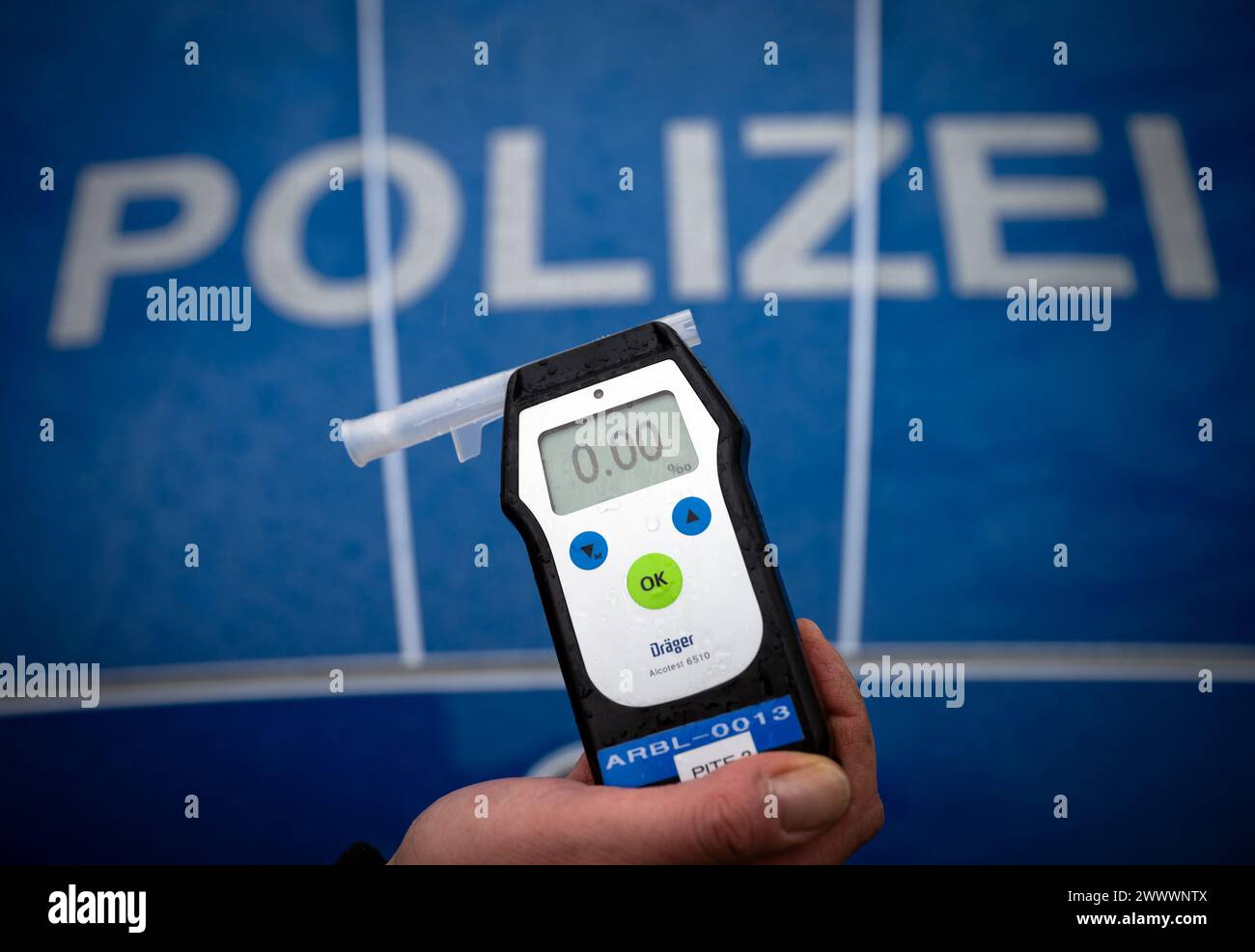 Trebbin, Deutschland. März 2024. Bei einer Verkehrshaltestelle in der Berliner Straße hält ein Polizist ein Alcotest-Messgerät, das einen Alkoholgehalt von Null pro Millile anzeigt. Quelle: Soeren Stache/dpa/Alamy Live News Stockfoto