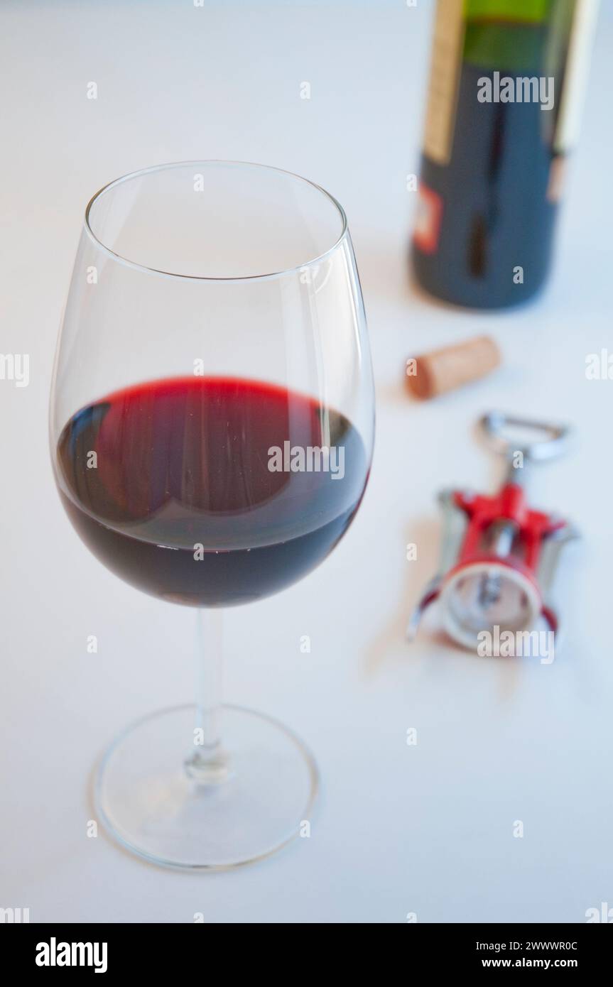 Glas Rotwein, Kork, Korkenzieher und Flasche. Stockfoto