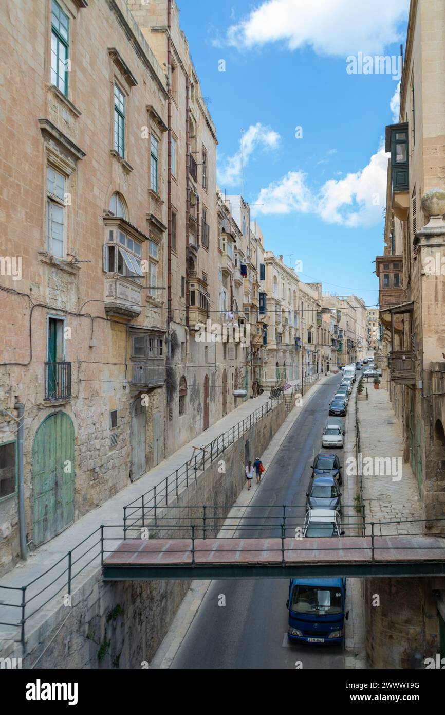 Triq Il-Lvant, Valletta, Malta - 16. August 2018: Eine Reihe von Autos, die durch die Straße fahren und von Apartments übersehen werden. Stockfoto