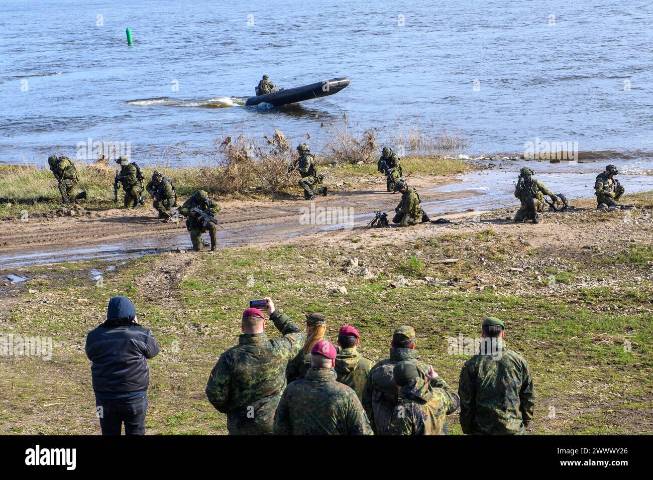 Storkau, Deutschland. März 2024. Soldaten der 4. Schnelleinsatzbrigade sichern das westliche Elbufer, nachdem sie von Schlauchbooten abgesetzt wurden. Die Wasserüberquerung der deutsch-tschechischen Kampfeinheit ist Teil der militärischen Übung Wettiner Schwert 2024. Die Übung ist wiederum Teil der großangelegten Übung „Quadriga 2024“. Quelle: Klaus-Dietmar Gabbert/dpa/Alamy Live News Stockfoto