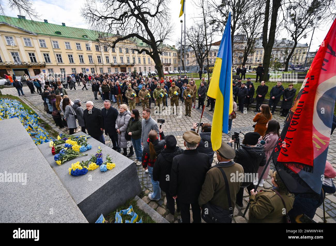Nicht exklusiv: LEMBERG, UKRAINE - 25. MÄRZ 2024 - Menschen legen Blumen am Denkmal für den Helden der Ukraine, Führer der Volksbewegung Ukr Stockfoto