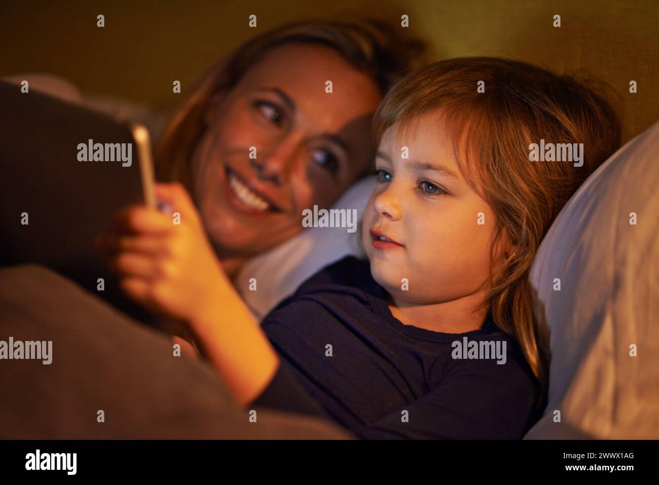 Nacht, Mutter oder Kind mit Tablet zum Streamen, Spielen oder Ansehen von Videos auf der Filmwebsite zu Hause. Soziale Medien, Kind oder glückliche Mutter mit Lächeln Stockfoto