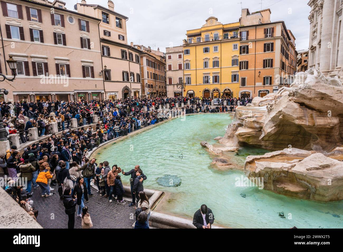 Menschenmassen drängen sich um den berühmten Trevi Brunnen in Rom, Italien. In der historischen Altstadt von Rom *** drängen sich Menschenmassen um den berühmten Trevi-Brunnen in Rom, Italien, im historischen Zentrum Roms Stockfoto