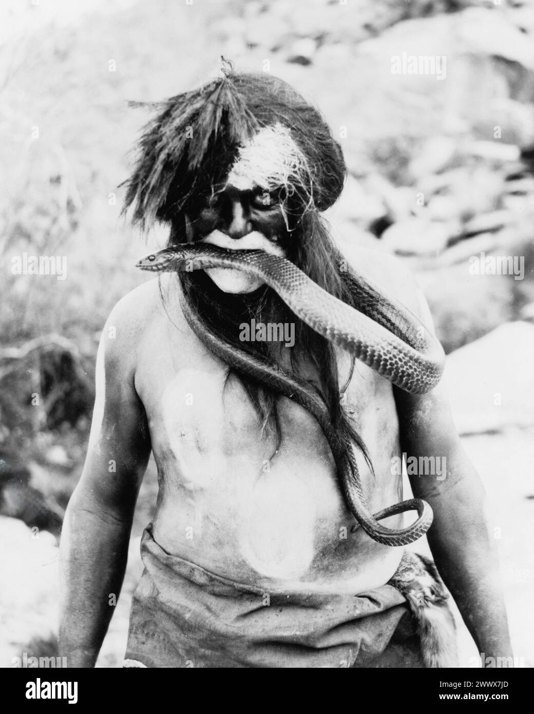 Hopi Indianer mit gemaltem Gesicht und Körper mit Schlange im Mund - 1924. Stockfoto