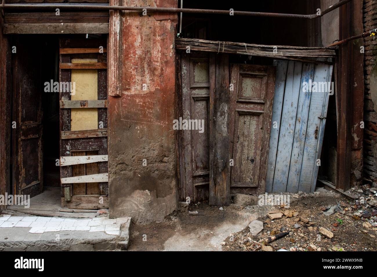 Verdrehte Holztüren und kaputte Gehwege durch verurteilte Gebäude in der Altstadt, eine beliebte Touristenattraktion in Tiflis, der Hauptstadt von Geor Stockfoto