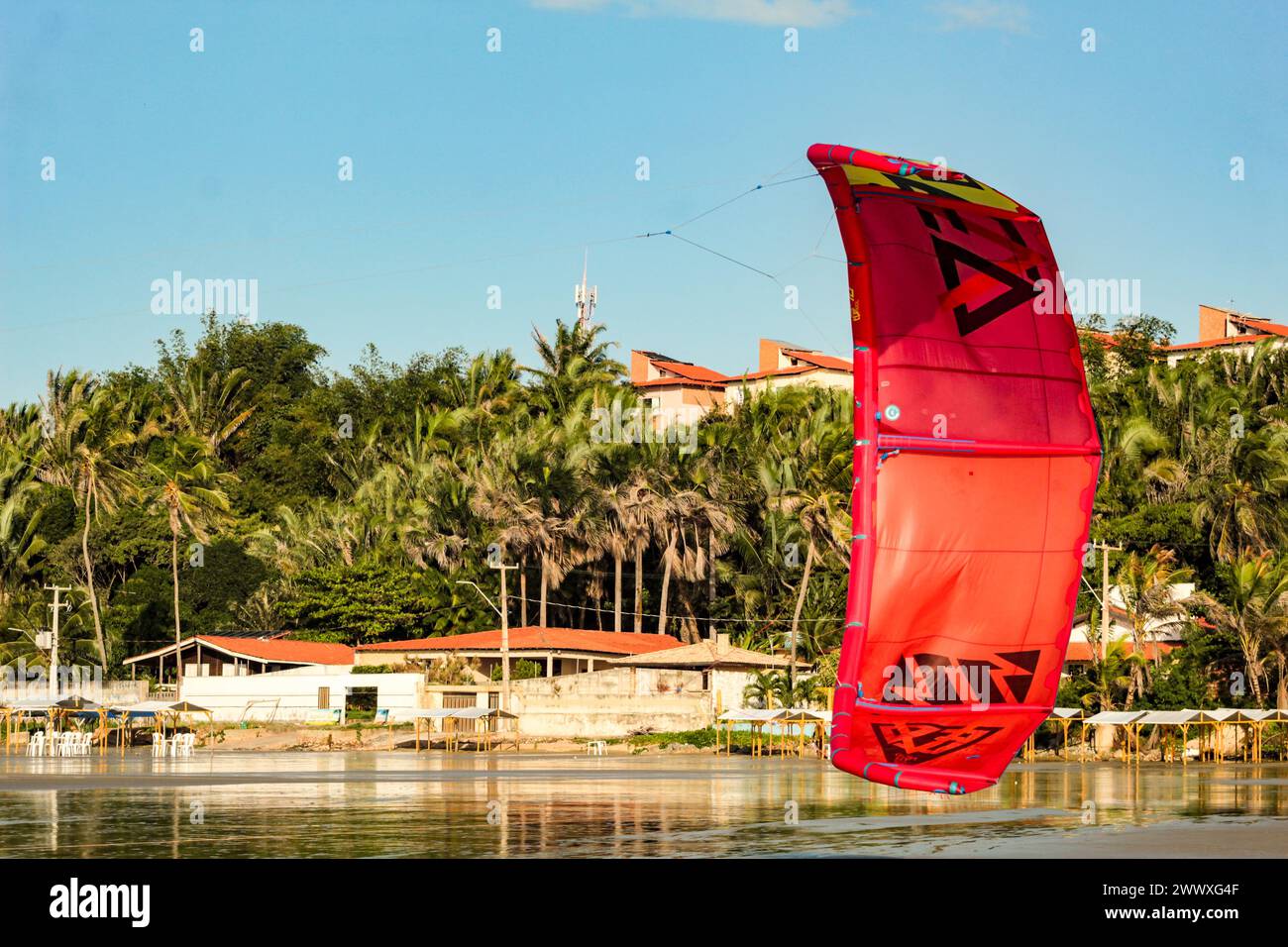Ein rotes Kitesurfsegel am Strand von Olho d'Água, Insel Maranhão, Bundesstaat São Luís, Nordosten Brasiliens Stockfoto