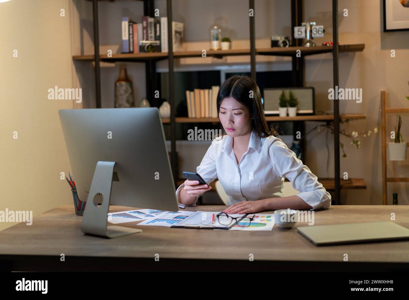 Die junge Frau arbeitet bis spät in die Nacht Stockfoto