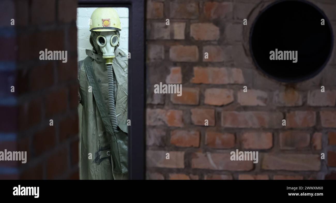 26. März 2024, Sachsen, Kšnigstein: Eine Schaufensterpuppe mit Schutzanzug und Gasmaske steht in einer Ecke während des Presserundgangs der neuen Ausstellung 'Nuklearbunker und Pulvermagazin' im ehemaligen Bunker für den DDR-Zivilschutz. Die Festung Königstein macht Räume des einst geheimen DDR-Bunkers im Festungswald, die in der Ausstellung selten zu sehen sind, im Rahmen von Führungen zugänglich. Foto: Robert Michael/dpa Stockfoto
