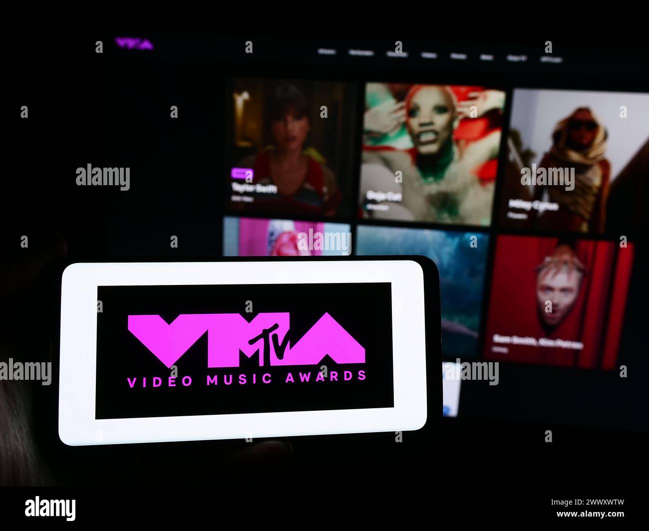 Person mit Smartphone und Logo der Preisverleihung MTV Video Music Awards (VMA) vor der Website. Schwerpunkt auf dem Display des Telefons. Stockfoto