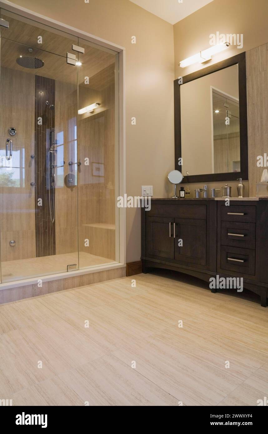 Hauptbadezimmer mit doppelter Dampfglas-Duschkabine und Kosmetikbereich in Erweiterung in luxuriösem Blockhaus, Quebec, Kanada Stockfoto