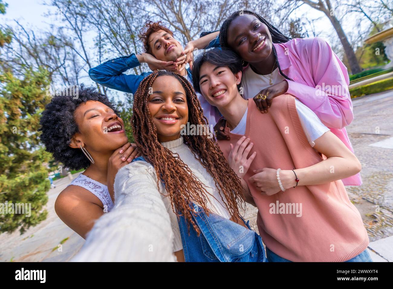 Persönliche Perspektive von fünf multiethnischen jungen Freunden, die Scherze machen, während sie ein Selfie in einem Stadtpark machen Stockfoto