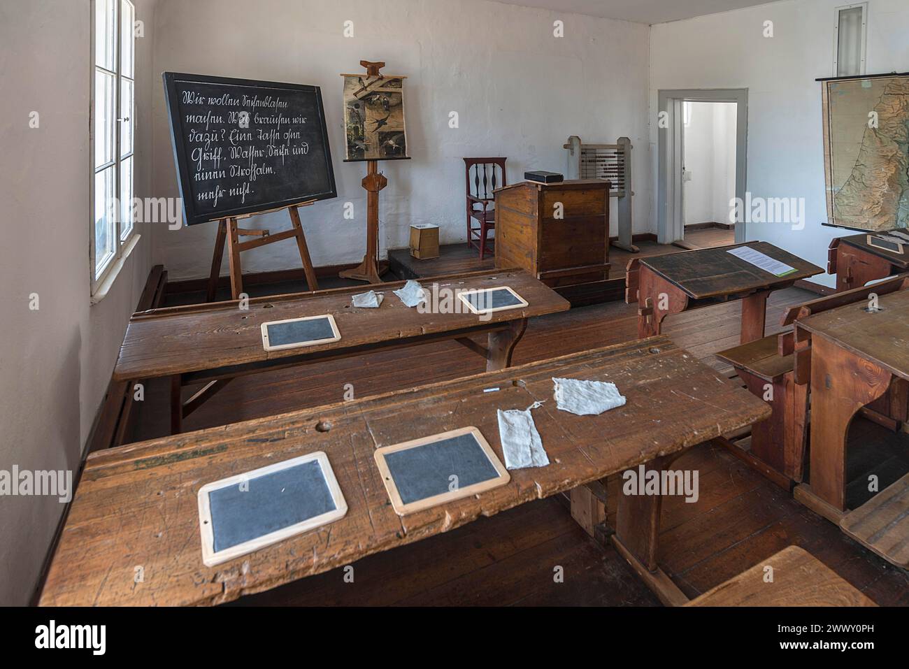 Tafel und Tücher auf den Schultischen, Tafel und Lehrerpult in einem Klassenzimmer aus dem 19. Jahrhundert, Freilichtmuseum für Folklore Stockfoto