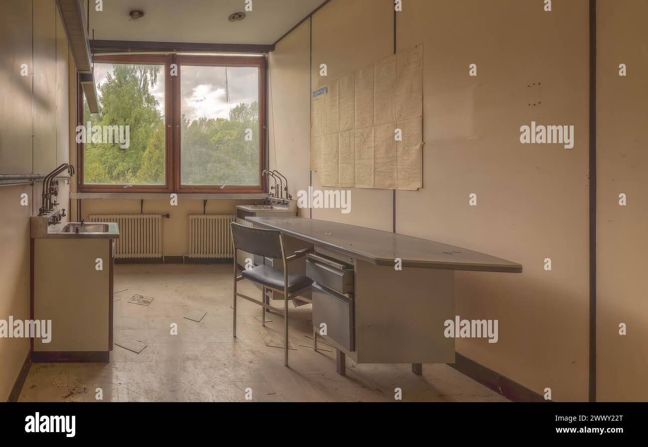 Leeres Zimmer mit Möbeln vor einem Fenster mit Blick auf das Grün, Institut für Molekularbiologie, Lost Place, Sint-Genesius-Rode, Provinz Stockfoto