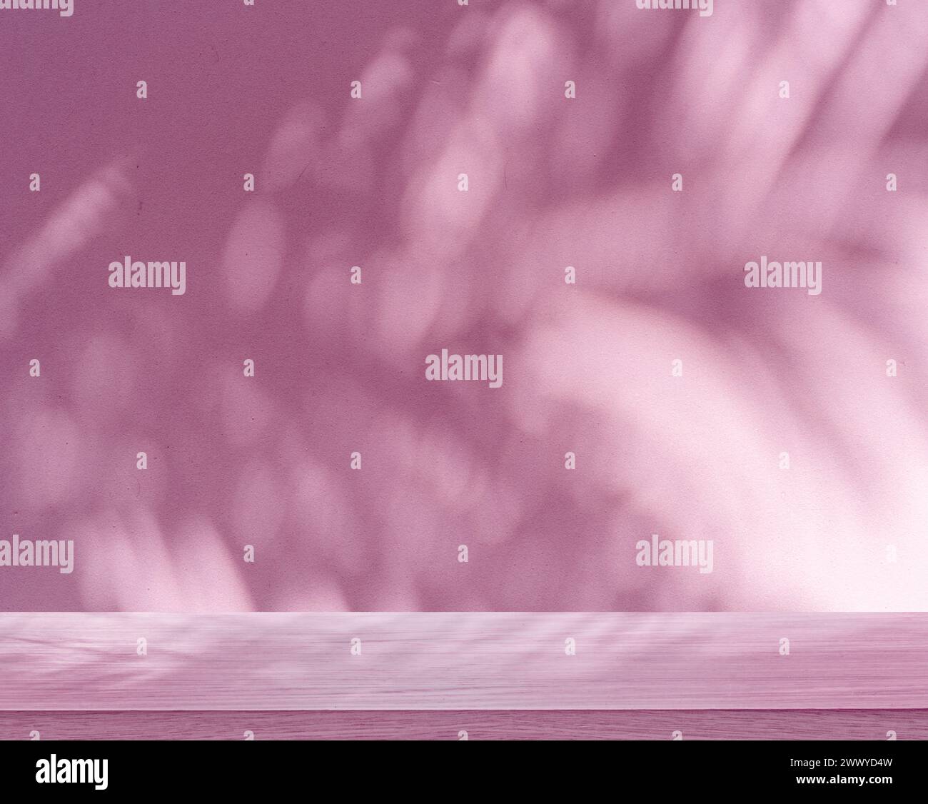 Verschwommener Schatten tropischer Palmenblätter auf rosa Wand und Tischplatte im Vordergrund. Sommerkonzept. Stockfoto
