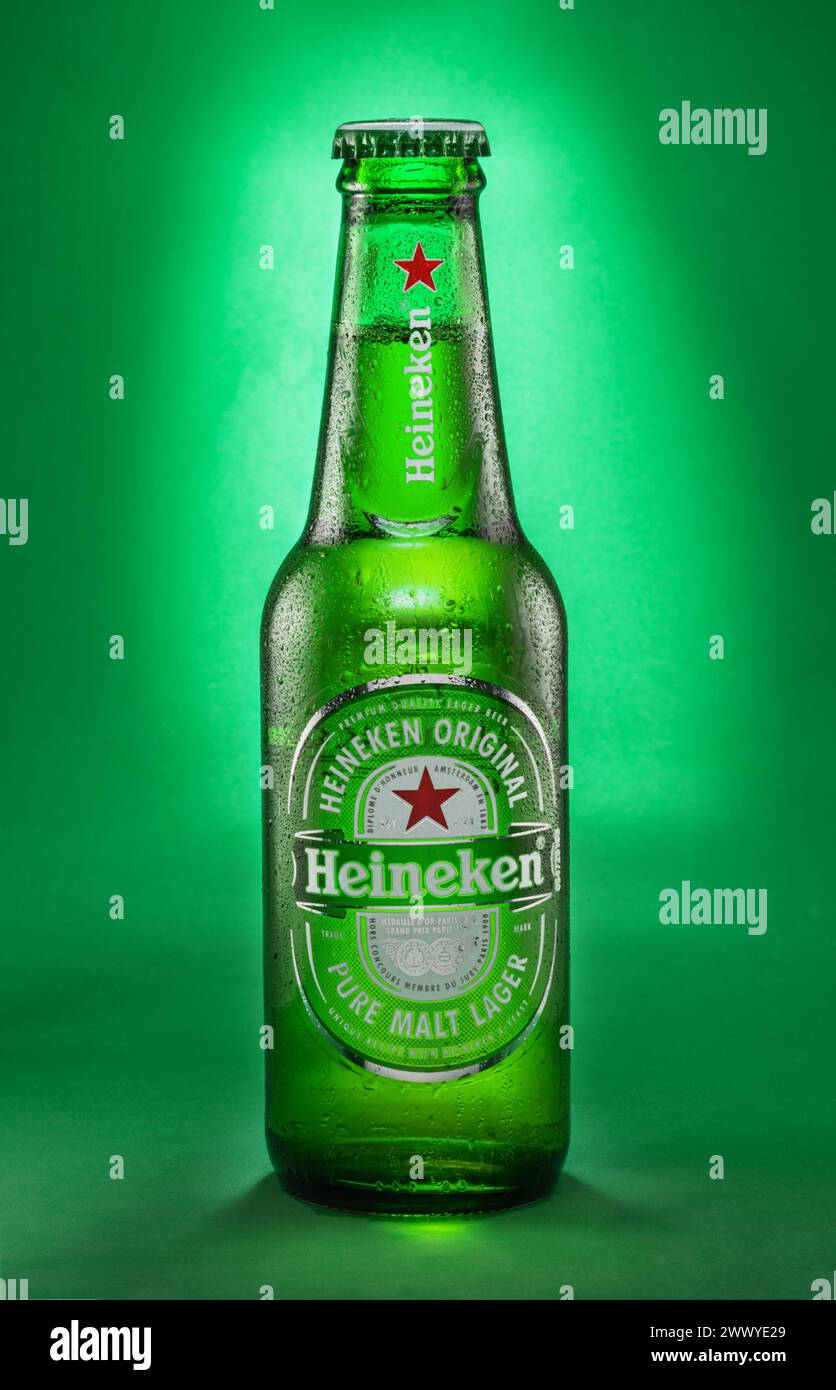 Portugal, Lissabon, 9. Dezember 2023: Flasche Heineken Lagerbier 0,33 l mit Tropfen auf grünem Hintergrund. Heineken ist ein niederländischer Bier-BH Stockfoto