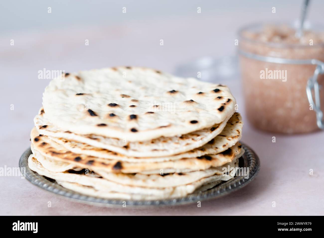 Handgemachte runde Matzo auf einem Teller. Süßes Gewürz mit Apfel-Walnuss-Charoset auf dem Tisch. Gesunde Ernährung. Jüdische Passahfeier. Leerzeichen für Text Stockfoto