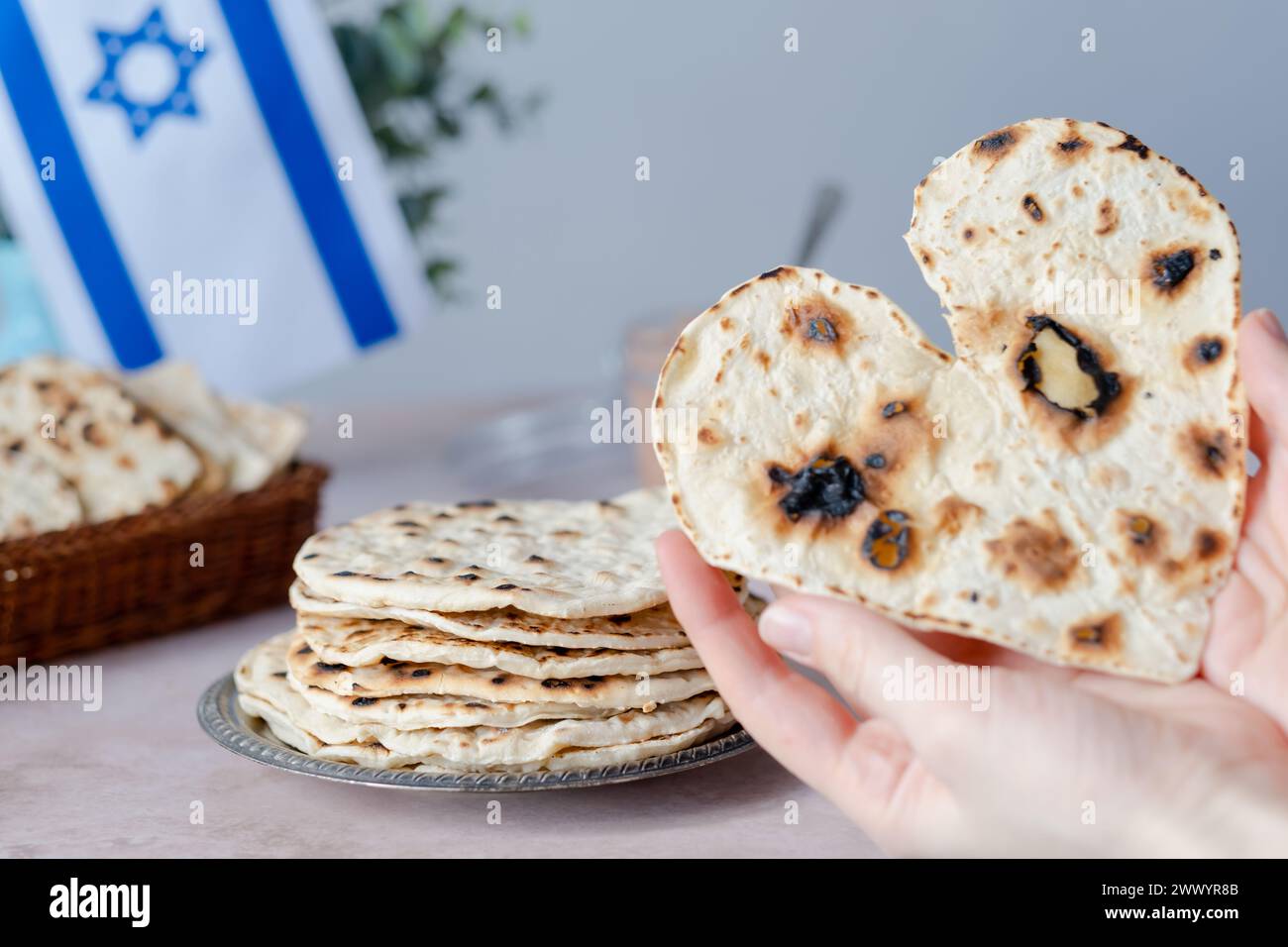 Hände mit herzförmiger Matzah. Gesunde Ernährung. Jüdisches Pessach-fest-Konzept. Stockfoto