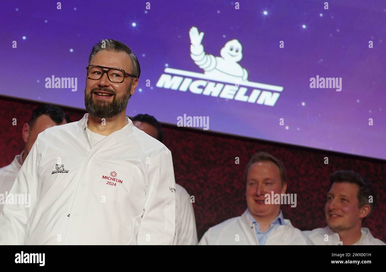 Hamburg, Deutschland. März 2024. Der 1-Sterne-Koch Andre Stolle vom Restaurant „Lisbeth“ in Hamburg steht bei der Verleihung der Michelin-Sterne 2024 für deutsche Restaurants in der Handelskammer auf der Bühne. Der diesjährige Michelin Guide listet 340 Restaurants auf, die in den letzten Monaten einen oder mehrere Sterne verdient haben, darunter zehn drei-Sterne-Restaurants. Quelle: Marcus Brandt/dpa/Alamy Live News Stockfoto