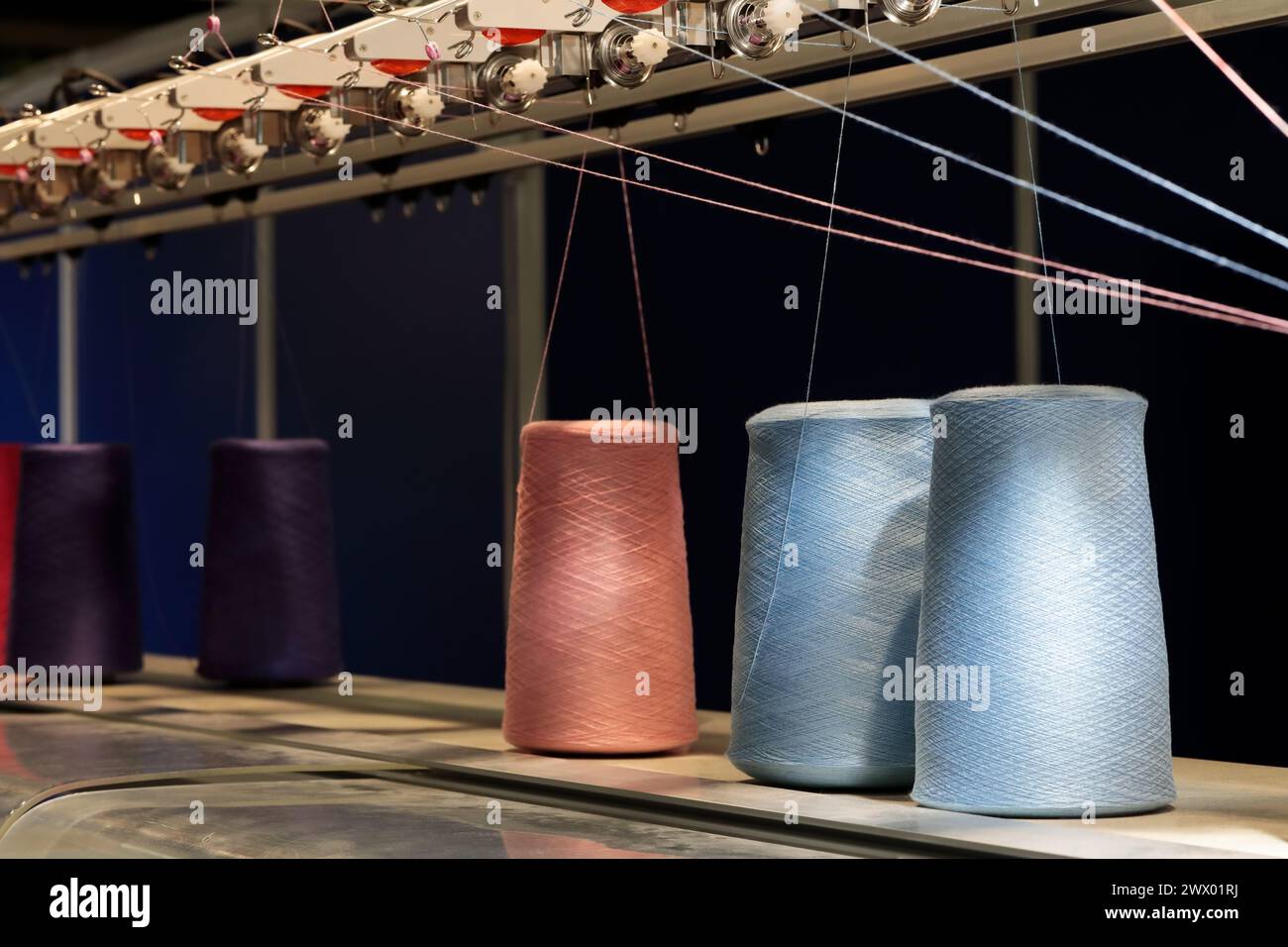 Gewindespulen und Fertigungsausrüstung. Konzept der Textil- und Textilindustrie. Selektiver Fokus. Stockfoto