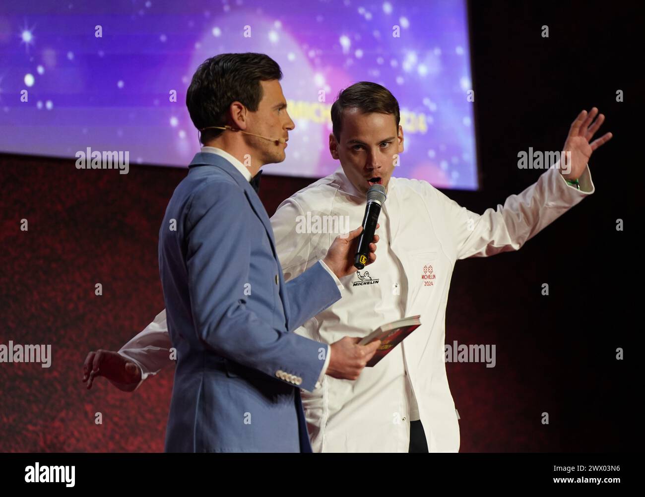 Hamburg, Deutschland. März 2024. Der 2-Sterne-Koch Roland Pieber (r) vom Restaurant „Seo Küchenhandwerk“ in Langenargen steht während der Verleihung der Michelin-Sterne 2024 für deutsche Restaurants in der Handelskammer auf der Bühne. Der diesjährige „Guide Michelin“-Restaurantführer listet 340 Restaurants auf, die in den letzten Monaten einen oder mehrere Sterne verdient haben, darunter zehn drei-Sterne-Restaurants. Quelle: Marcus Brandt/dpa/Alamy Live News Stockfoto