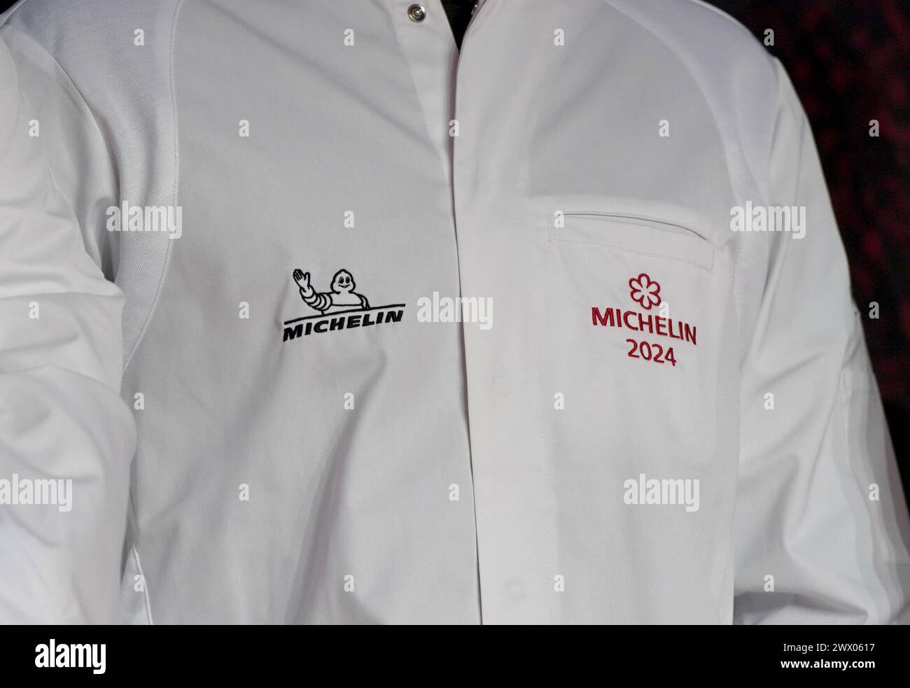 Hamburg, Deutschland. März 2024. Ein Preisträger trägt seine 1-Sterne-Küchenjacke auf der Bühne während der Verleihung der Michelin-Sterne 2024 für deutsche Restaurants in der Handelskammer. Der diesjährige „Guide Michelin“-Restaurantführer listet 340 Restaurants auf, die in den letzten Monaten einen oder mehrere Sterne verdient haben, darunter zehn drei-Sterne-Restaurants. Quelle: Marcus Brandt/dpa/Alamy Live News Stockfoto