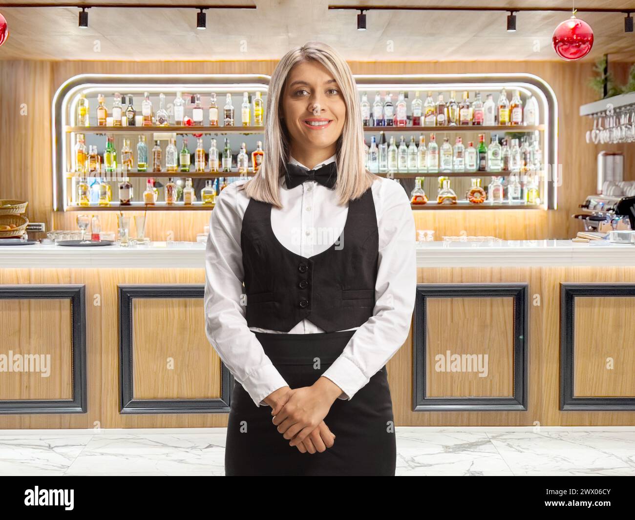 Kellnerin in Uniform posiert und lächelt in einer Hotelbar Stockfoto