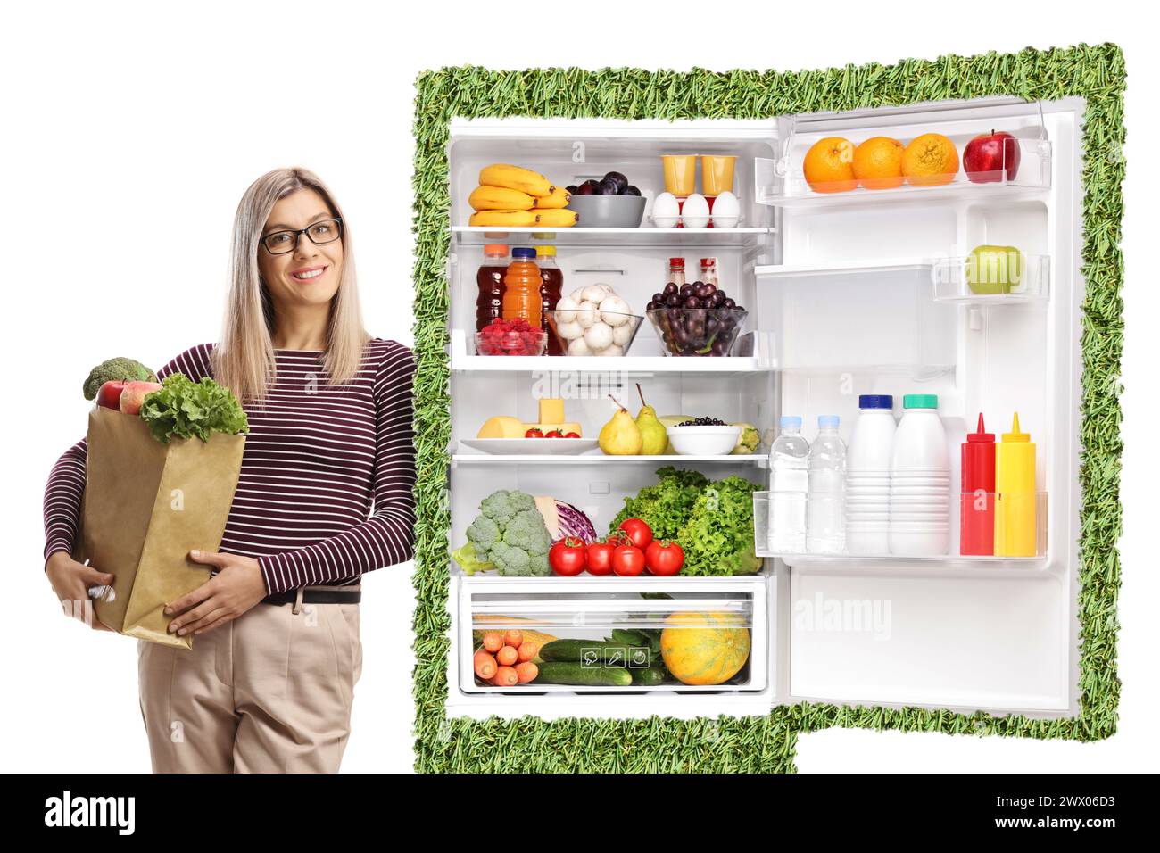 Junge Frau mit einer Lebensmitteltasche, die sich auf einen nachhaltigen Kühlschrank stützt, isoliert auf weißem Hintergrund Stockfoto