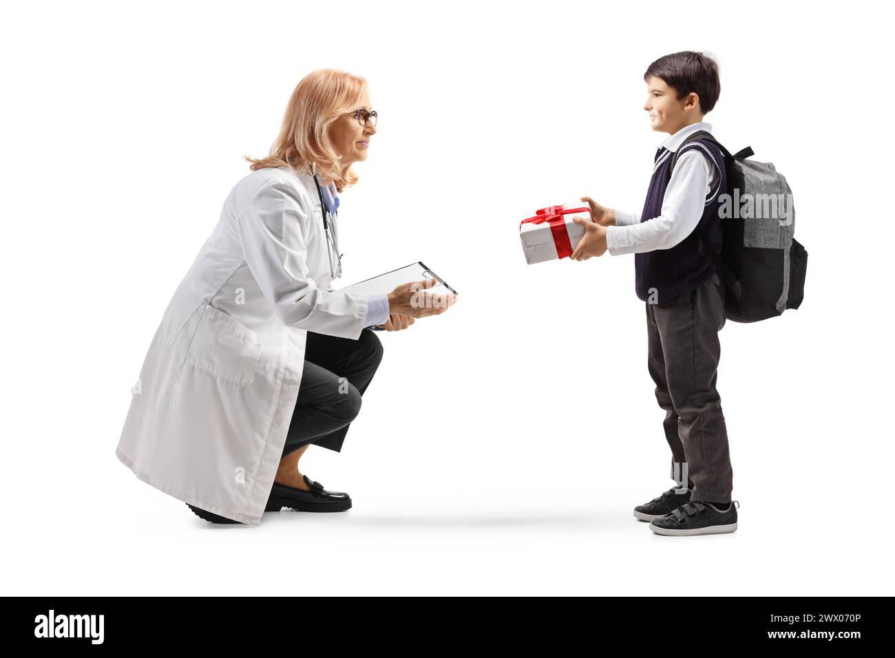 Junge, der einer Ärztin ein Geschenk gibt, isoliert auf weißem Hintergrund Stockfoto