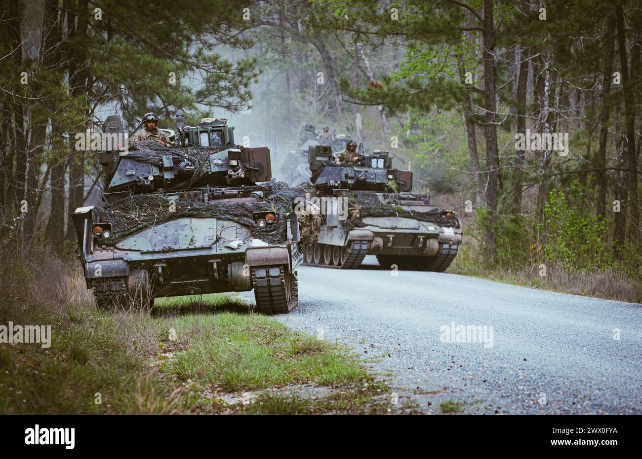 Leichte gepanzerte Infanterieeinheiten, die dem 3. Bataillon, 69. Panzerregiment, 1. Panzerbrigade Combat Team, 3. Infanteriedivision, zugewiesen sind, durchqueren eine feindliche Zone im Joint Readiness Training Center (JRTC), Fort Johnson, Louisiana, 20. März 2024. Infanterie-Einheiten trainierten zusammen mit gepanzerten Kollegen, um ihre Zusammenhalt und Letalität zu erhöhen. (Foto der US-Armee von PFC. Luciano Alcala) Stockfoto