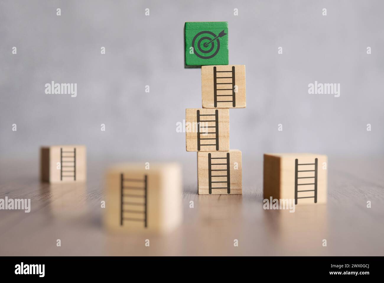 Holzblocktreppe mit ungleichmäßigen Stufen, die zu einem Zielbrett führen. Hürden beim Erreichen der Ziele Konzept. Stockfoto