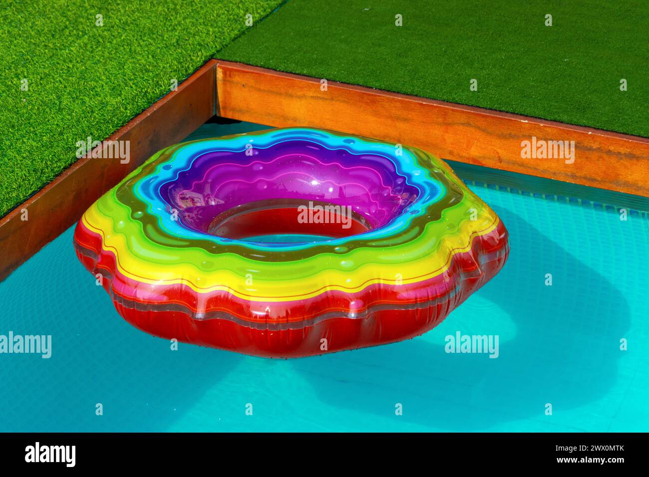 Farbenfroher aufblasbarer Ring auf der Oberfläche des Schwimmbades Stockfoto