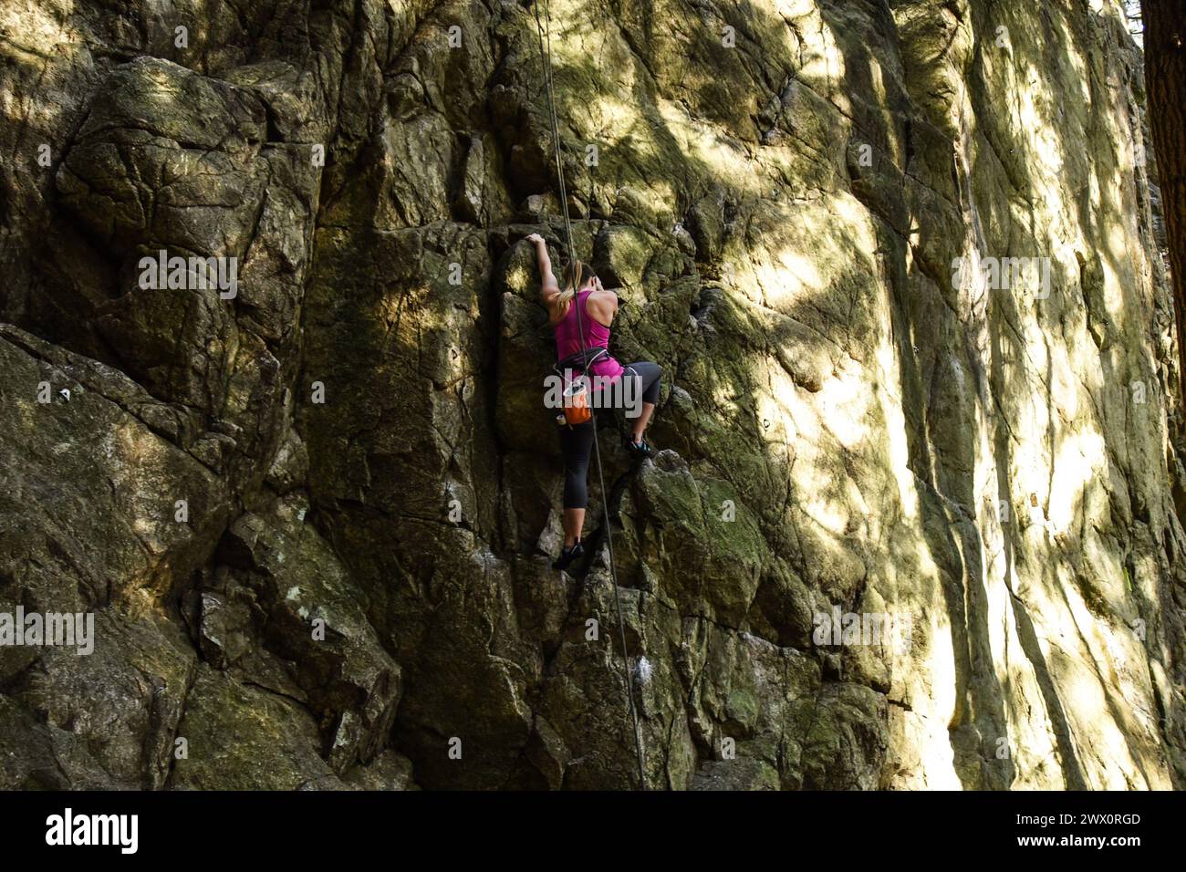Frau klettert am Sully's Hangout im Lynn Canyon, North Vancouver, Kanada Stockfoto