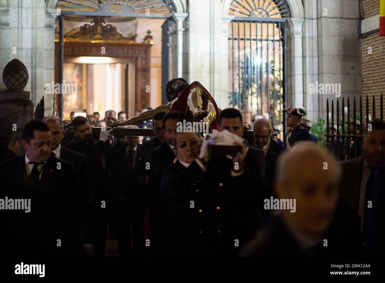 Mitglieder der Bruderschaft des Christus der Halberdiers tragen auf ihren Schultern das Bild des Christus der Halberdiers, als sie die Militärkathedrale in Richtung Königspalast verlassen. In diesem Jahr verzögerte der Regen ihre Abreise. Die Mitglieder der Königlichen Kongregation des Heiligen Christus des Glaubens, Christus der Helleberdiers und Maria Unbefleckte Königin der Engel der Kathedrale der Streitkräfte führen die traditionelle Übertragung des Bildes des Christus der Helleberdiers in den Königlichen Palast von Madrid durch, um es für die Prozession vorzubereiten, die am nächsten Karfreitag durch die Straße geht Stockfoto