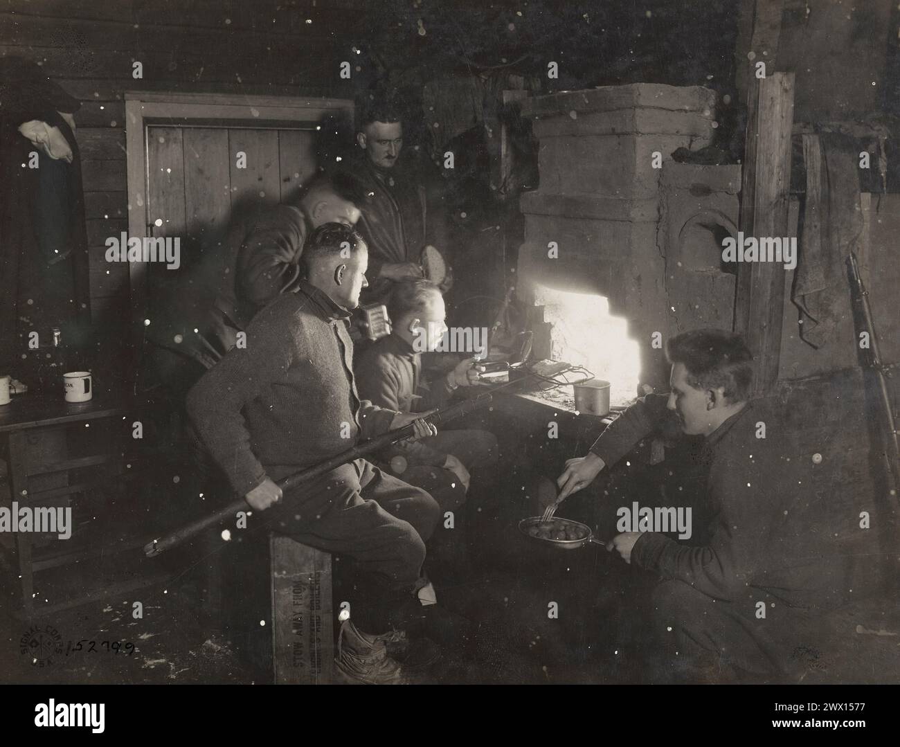 Eine amerikanische medizinische Abteilung, die in einem russischen Haus in der Nähe der Touglas-Front in Chamova, Russland, ein Silvesterdinner in einem großen niederländischen Ofen vorbereitet, der in jedem Bauernhaus ca. 1918 Stockfoto