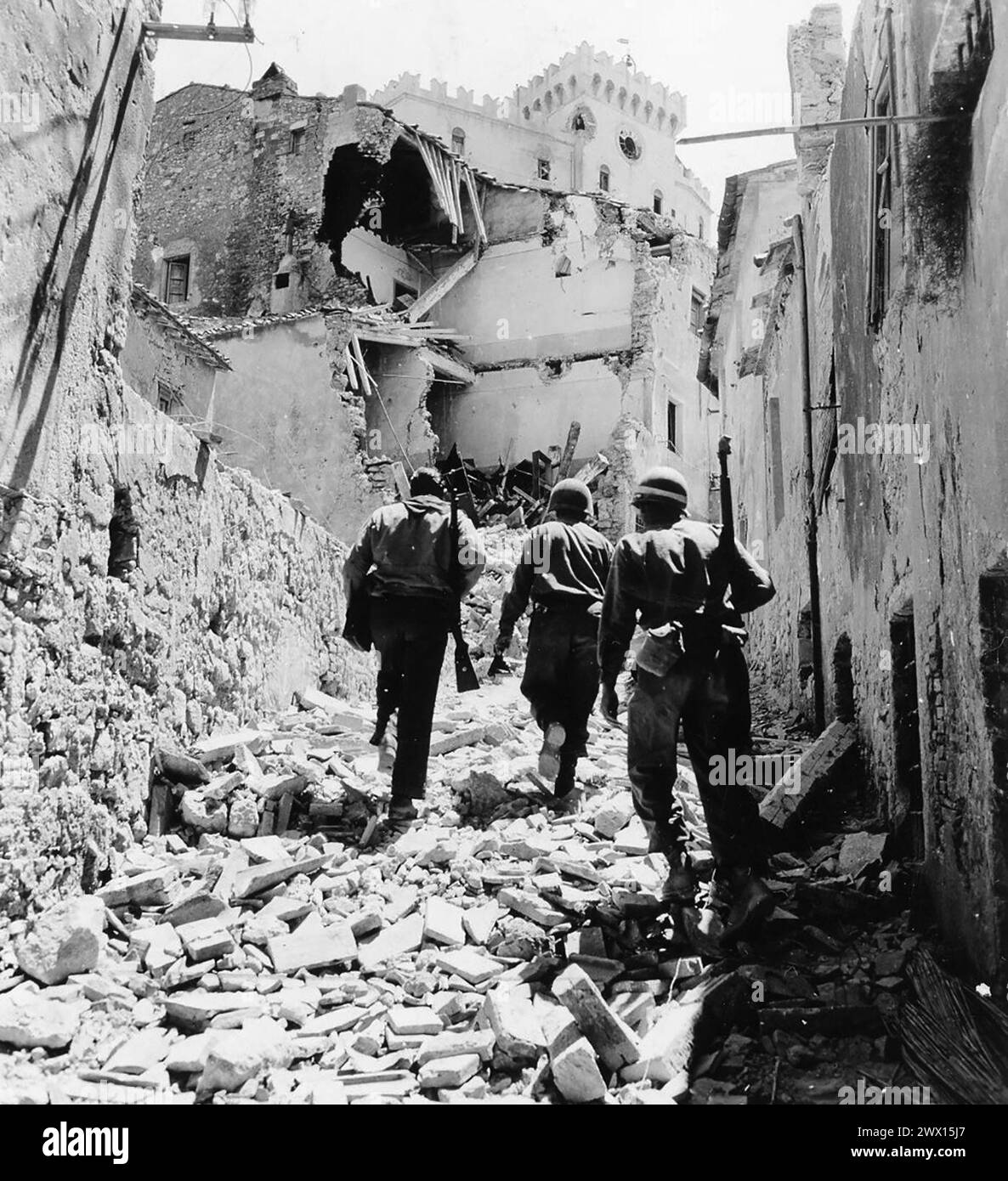 Originalüberschrift: 'Fünfte Armee, Rosignano Gebiet, Italien. Zwei amerikanische Infanteristen der 34. Infanterie-Division laufen mit einer italienischen Partisanen durch die Stadt Rosignano. 1944 Stockfoto
